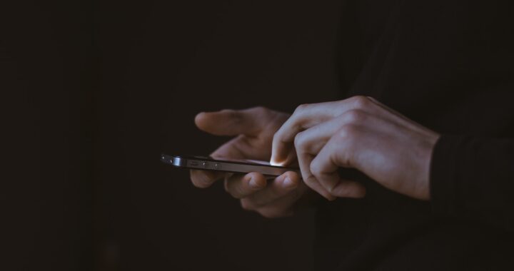Fotografia em cores de mãos manipulando um celular.