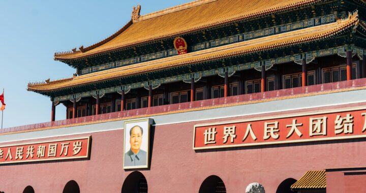 Fotografia em cores da Porta de Tiananmen com bandeiras chinesas